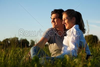 Couple on meadow in sunset