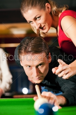 Couple playing billiards