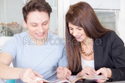 couple reading magazine and laughing