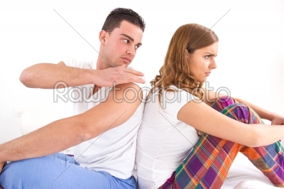 couple sitting separately from each other on the bed
