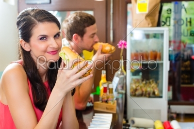 Customers eating Hotdog in fast food snack bar
