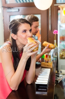 Customers eating Hotdog in fast food snack bar