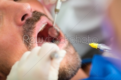 Dentist giving treatment - anesthetization syringe 