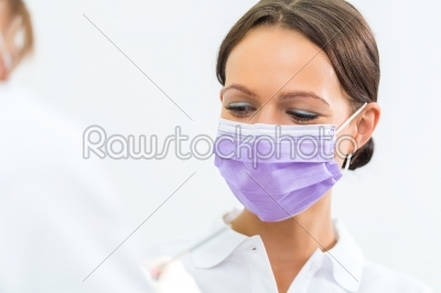 Dentist in her practice giving dental treatment