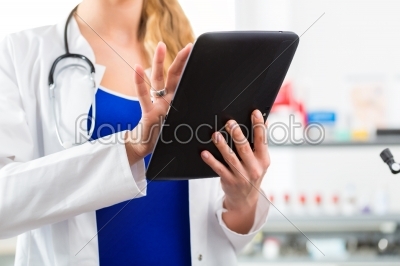 Doctor in clinic reading digital file on tablet computer