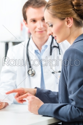 Doctor with patient in clinic consulting 
