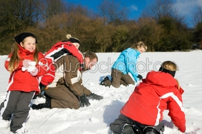 Family having a snowball fight