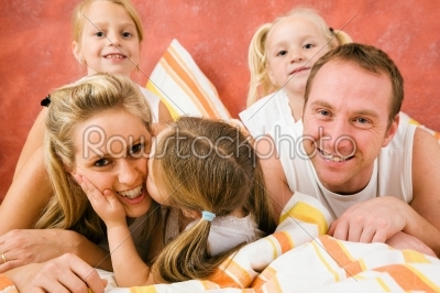 Family in bed - a little kiss