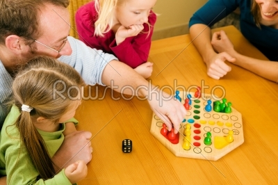 Family is playing ludo together