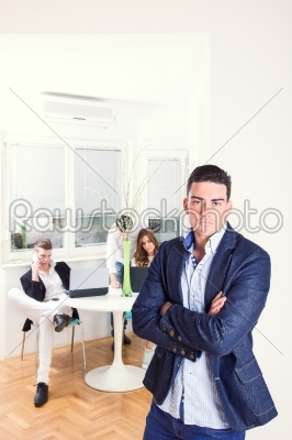 fashion man standing in business atmosphere with colleagues in b