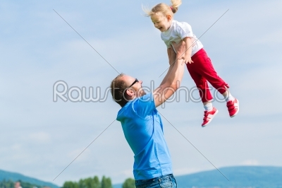 Father and daughter on a summer meadow