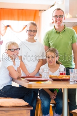 Father and daughters in kitchen eating healthy
