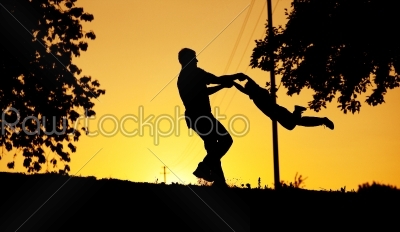 Father and son playing at sunset