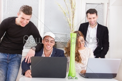 friendly team looking at laptop computer smiling