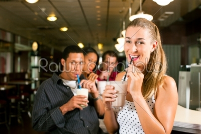 Friends drinking milkshakes in a bar