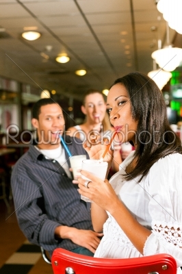Friends drinking milkshakes in a bar