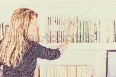 girl taking a book from top shelf
