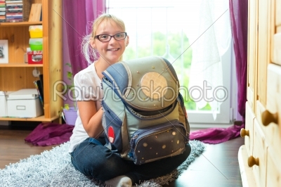 Girl with school bag in her room at home