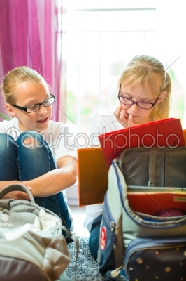 Girls doing homework and packing school bags