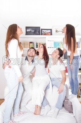 group of friends looking up indoors with books behind