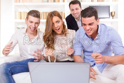 group of friends watching and working together at laptop