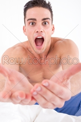 half naked man in bed with hands out towards camera
