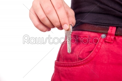 Hand puts the key in red jeans pocket