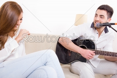 handsome man playing guitar to girl