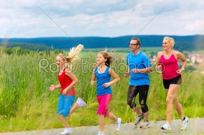 Happy Family is running outdoors in summer
