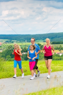 Happy Family is running outdoors in summer