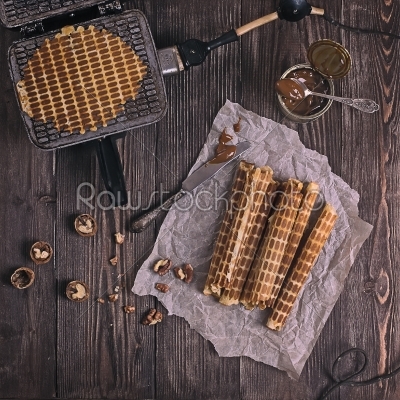 Homemade waffles with waffle iron on wooden table