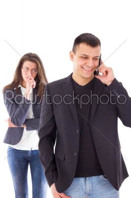 Jealous woman looking at her partner chatting on the phone