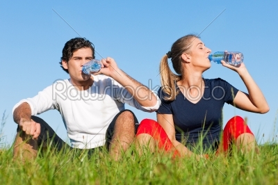 Jogger couple resting and drinking water