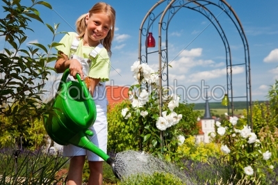Little girl watering the flowers