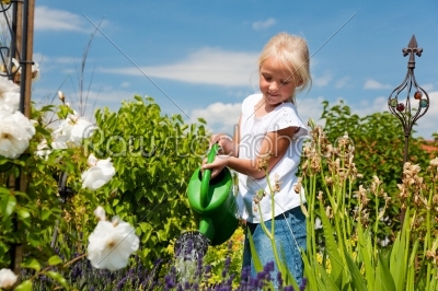 Little girl watering the flowers