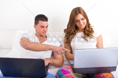 Man and woman both with computer, woman upset and surprised man 
