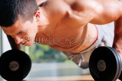 Man exercising  in gym - push ups 
