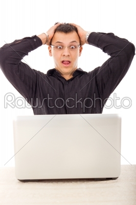 man in black shirt looking at laptop with wide eyes open