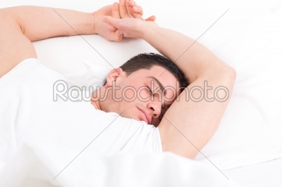 man lying in bed and having sweet dreams while sleeping