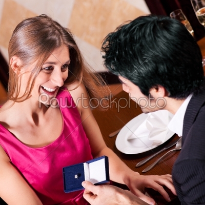 Man proposing to woman in restaurant