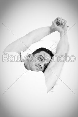 man waking up in the bedroom and stretches