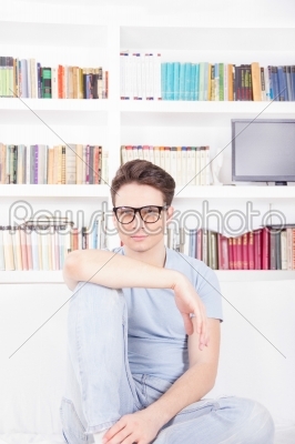 man with glasses posing in front of library