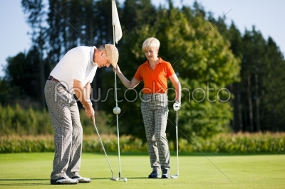 Mature couple playing Golf