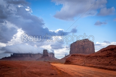 Monument valley road with big thunder cloud in background