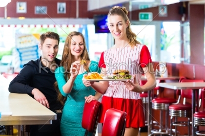 People in American diner or restaurant and waitress