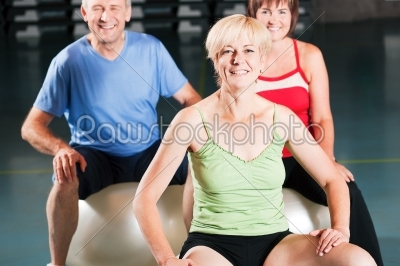 People in gym on exercise ball