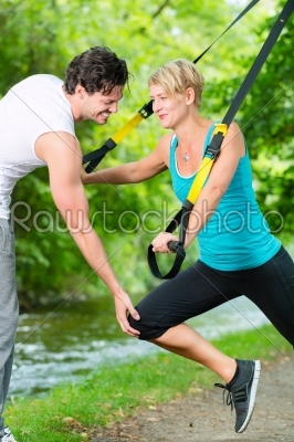 People in park on suspension or sling trainer
