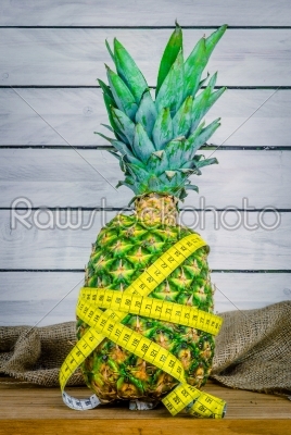 Pineapple with measure tape on a table
