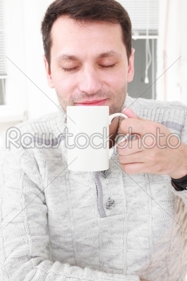 Portrait of a calm man having a coffee in his living room