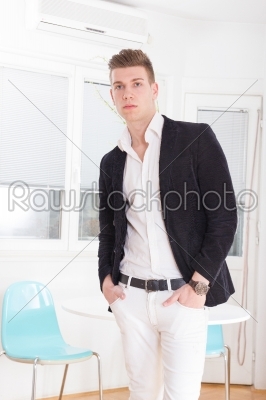 Portrait of a handsome fashionable man posing in the interior